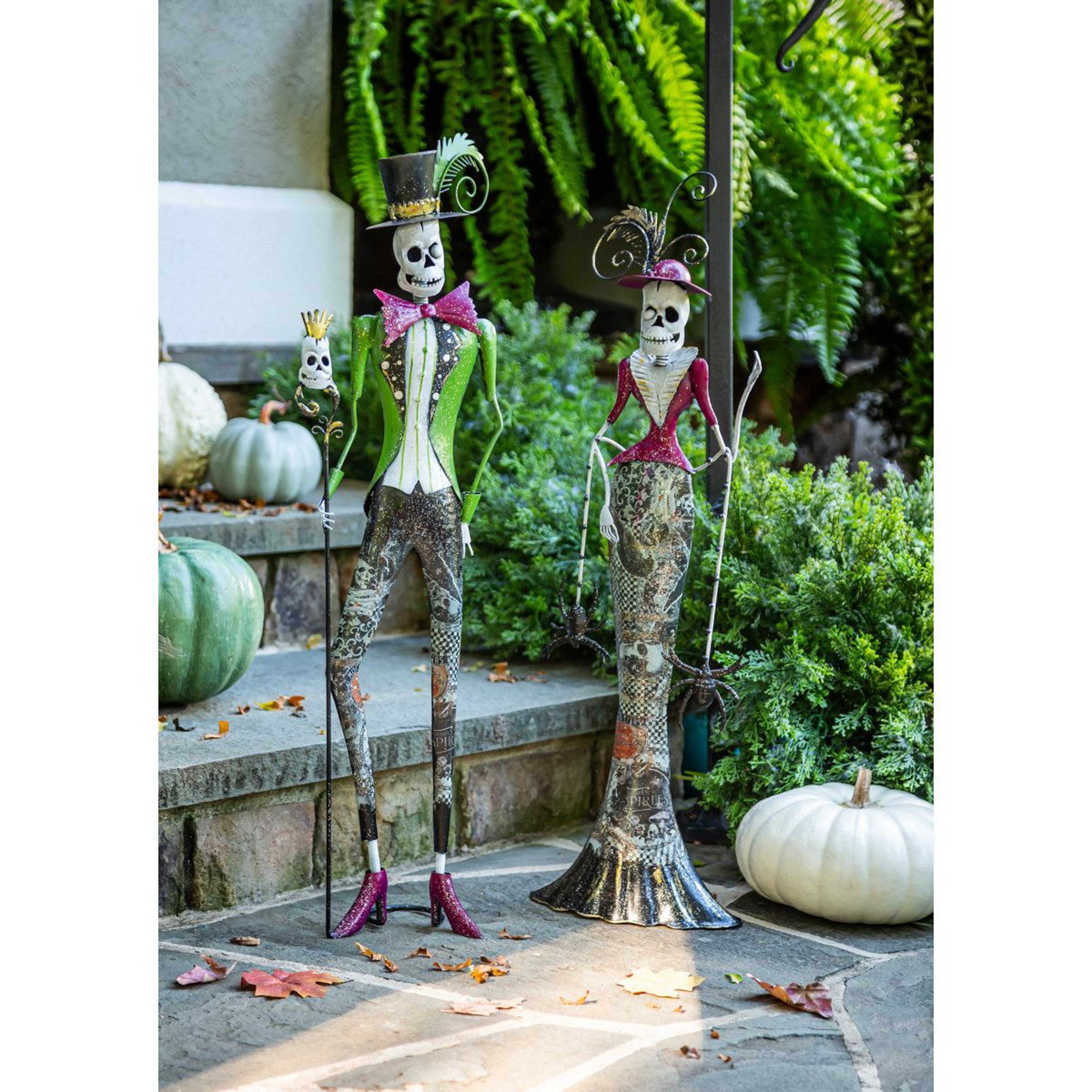 metal skeleton man with top hat and woman with spiders statue