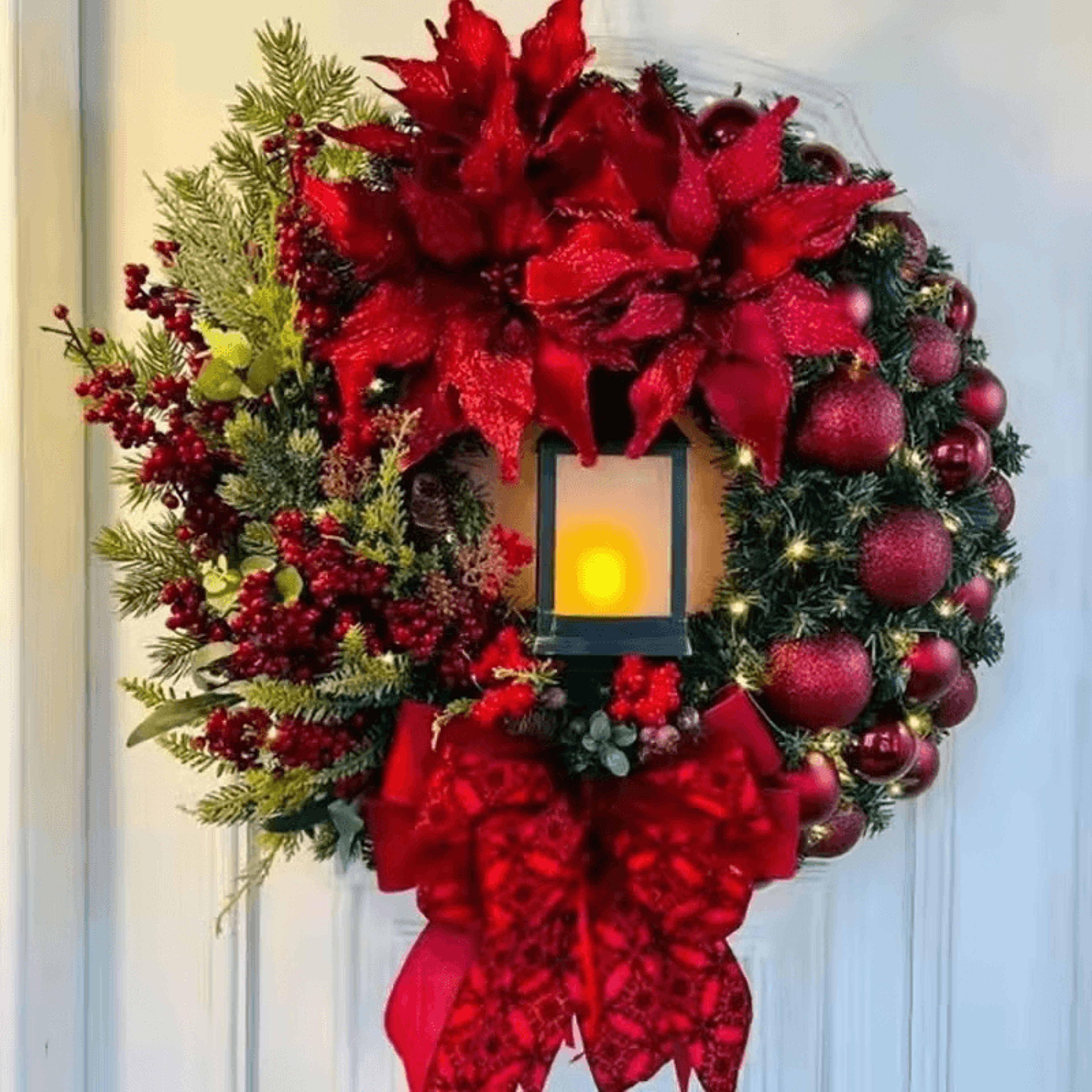 Holiday wreath with glowing LED lantern and bow